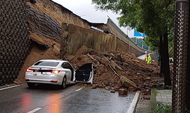 지난 16일 경기 오산시 가장교차로 고가도로 옹벽이 무너져 소방관들이 매몰된 차량 구조작업을 하고 있다. 경기도소방재난본부 제공