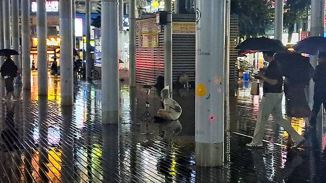 ▲&nbsp;지난 19일 부천역 북부광장에는 비가 오는 날씨에도 우비를 입고 카메라를 삼각대에 고정한 채 개인 방송을 하는 BJ·유튜버들이 여럿 있었다./ 추정현 기자 chu3636@incheonilbo.com