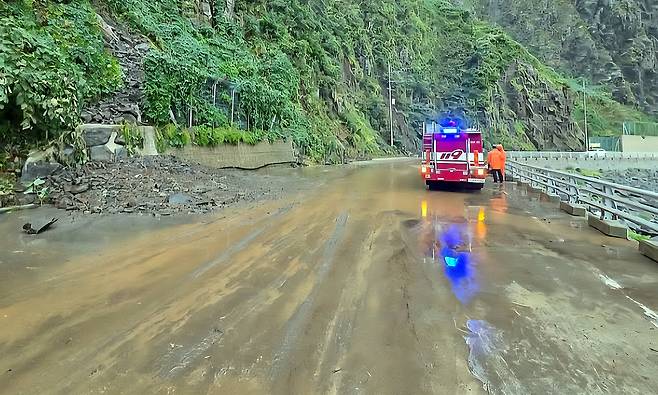 집중호우로 토사가 섬일주도로로 유입되자 소방차가 물을 뿌리고 있다. /김두한 기자