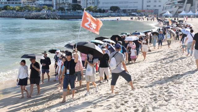 지난 20일 오후 부산 서구 송도해수욕장에서 열린 ‘맨발걷기 좋은 도시 부산 세븐비치 어싱 챌린지’ 행사에서 참가자들이 맨발로 바닷가를 걷고 있다. 이재찬 기자 chan@