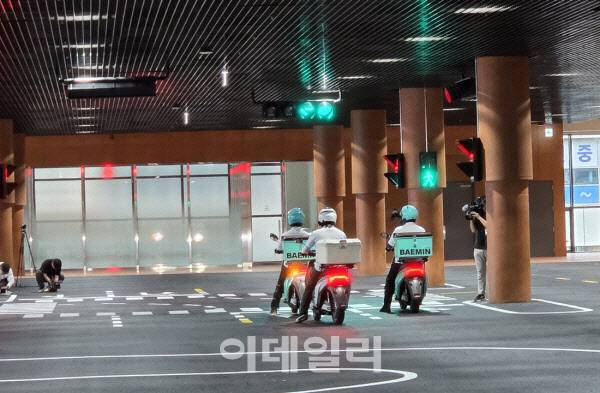 배민 로고가 새겨진 이륜차를 타고 신호등 앞에 멈춰 선 강사들. 실제 도로 환경을 그대로 옮겨 놓은 듯한 훈련장 전경이다. (사진=한전진 기자)