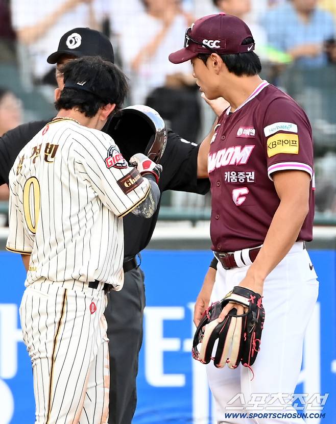 송성문에게 공에 맞은 귀를 보여주는 황성빈