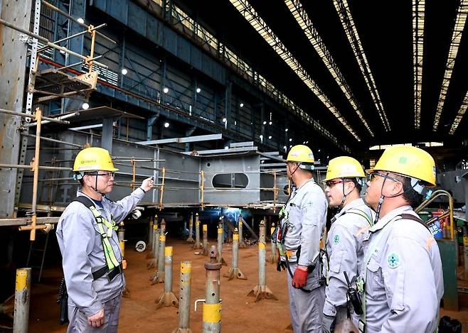 지용관 HJ중공업 생산본부 상무(왼쪽 첫번째)가 지난 18일 부산시 영도구 소재 HJ중공업 영도조선소에서 작업 내용을 설명하고 있다. HJ중공업 제공