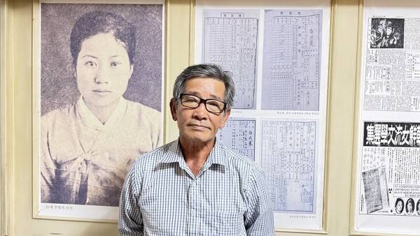 이중기 시인이 백신애 작가 사진을 배경으로 사진을 찍고 있다. 강성만 선임기자