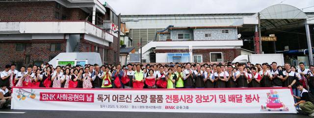 20일 창원시 의창구 명서시장에서 BNK경남은행을 포함한 BNK금융그룹 임직원들이 BNK사회공헌의 날을 맞아'독거 어르신 소망 물품 전통시장 장보기 및 배달 봉사활동'에 앞서 단체 기념촬영을 하고 있다.BNK금융그륩 제공