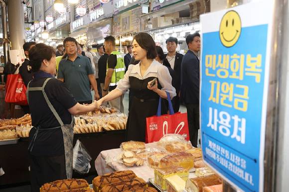 김혜경 여사가 7월 25일 인천 계양산전통시장을 방문해 제과점에서 민생회복 소비쿠폰을 이용해 제품을 구매하며 상인과 인사하고 있다. 2025.7.25 [사진=대통령실통신사진기자단]