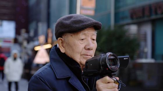 다큐멘터리 '미스터김, 영화관에 가다'에서 김동호 전 부산국제영화제 집행위원장이 캠코더를 들고 극장을 촬영하고 있다. 사진 메가박스중앙