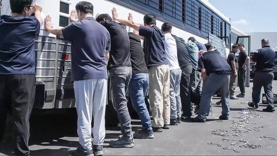 미국 이민세관단속국(ICE)과 국토안보수사국(HSI) 등 소속 요원들이 4일(현지시간) 현대자동차와 LG에너지솔루션이 조지아주 서베나에 공동으로 건설중인 배터리 공장에서 불법체류자 단속을 벌여 475명을 단속했다. 이 중 300여명이 한국인으로 파악된다. 사진은 이날 단속 요원들이 현장 직원들의 몸과 다리를 수갑과 쇠사슬로 묶고 있는 모습. [사진 ICE 동영상 캡처]