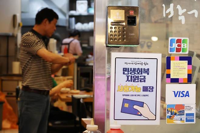 22일부터 전 국민의 90%에 2차 민생회복 소비쿠폰이 1인당 10만원씩 지급 된다. 사진은 지난 12일 서울 시내의 한 가게에 붙은 민생회복 소비쿠폰 사용처 안내문. 연합뉴스