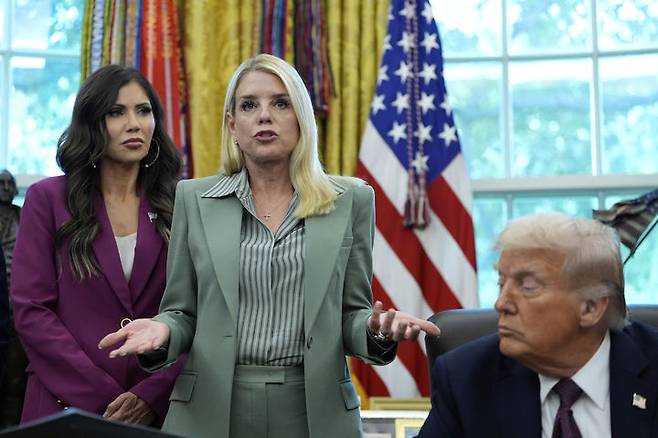 [워싱턴=AP/뉴시스]팸 본디 미 법무장관(가운데)이 15일 백악관 대통령 집무실에서 발언하는 것을 도널드 트럼프 대톻령이 듣고 있다. 본디는 찰리 커크의 10일 피살 후 증오 발언을 처벌하겠다고 밝혔으나 보수파의 비난을 사자 방향을 돌려 '커크 비난' 처벌을 노골화하고 있다. 왼쪽은 크리스티 놈 국토부장관. 025.9.17.
