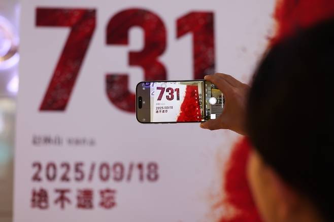 중국 북부 허베이성 스자좡의 한 영화관에서 관객이 영화 731 포스터를 촬영하고 있다. 이 영화는 제2차 세계대전 당시 일본의 악명 높은 731부대의 만행을 다룬 작품으로, 18일 중국 전역 극장에서 개봉했다. 신화 뉴시스