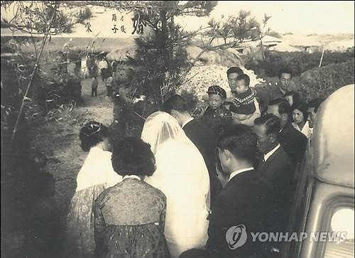 1960년대 제주도의 혼례 모습     (서울=연합뉴스) 1966년 제주도 혼례 풍습의 한 장면. 신랑집으로 들어가는 신부를 구경하는 동네 사람들의 모습이 담겨 있다. [연합뉴스 자료사진]