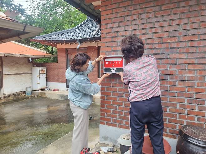 홀몸어르신 주택에 우편함을 설치하고 있는 화도면 지역사회보장협의체 회원. <사진=인천 강화군 제공>