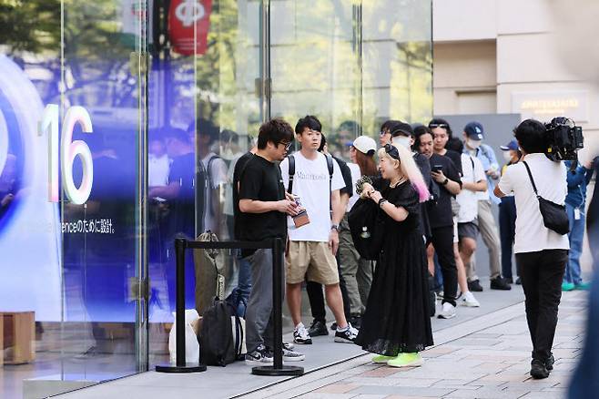 도쿄 도심 한 거리의 매장 앞에서 애플의 신형 스마트폰을 구매하기 위해 사람들이 줄을 서고 있다. 해당 사진은 기사와 직접적 관련이 없음. (사진= 지지프레스)