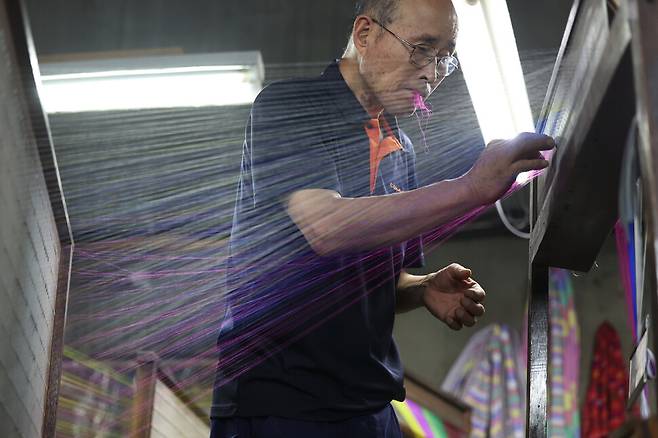 지난 15일 충남 공주시 유구읍 동원직물 공장에서 조건환씨가 여러 색의 실을 정경기에 연결하고 있다. 백소아 기자 thanks@hani.co.kr