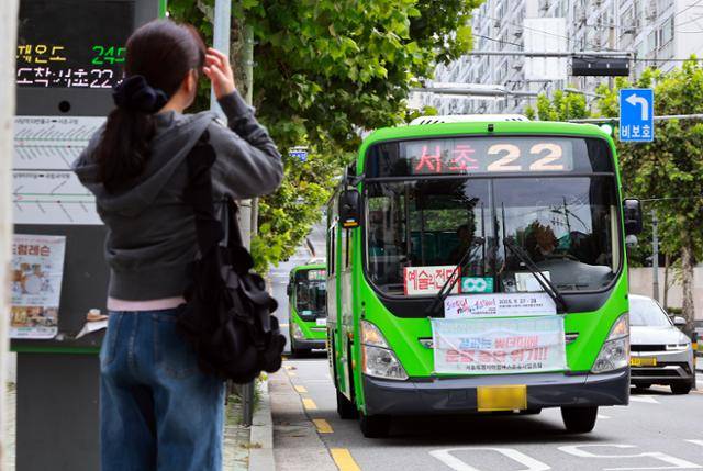 서울시마을버스운송사업조합이 내년 1월 1일부터 환승제도에서 공식 탈퇴하겠다고 밝힌 22일 서울시내 버스정류장에서 한 시민이 마을버스를 기다리는 모습. 연합뉴스