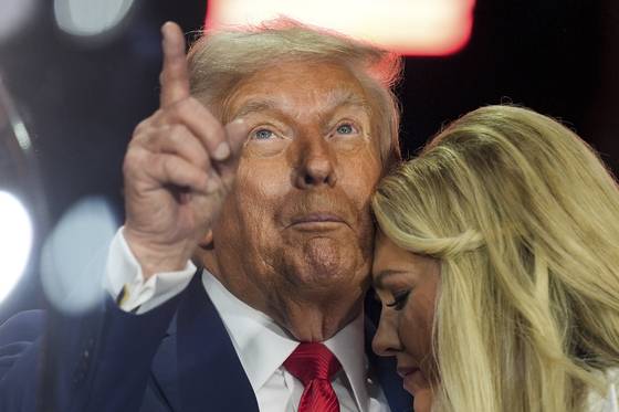 도널드 트럼프 대통령이 21일(현지시간) 애리조나주 글렌데일 스테이트팜 스타디움에서 보수운동가 찰리 커크의 추모식에서 커크의 배우자 에리카와 포옹하며 하늘을 가리키고 있다. AP=연합뉴스