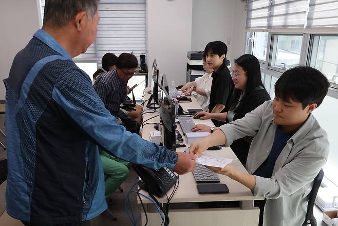 22일 부산 부산진구 가야2동주민센터에서 시민들이 지원금을 받고 있다. 송봉근 기자