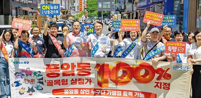 김이강 광주광역시 서구청장(앞줄 가운데)과 풍암동 상인회원들이 지난 6월 먹자골목 일원에서 온누리상품권 알리기 캠페인을 하고 있다.  광주시 서구 제공