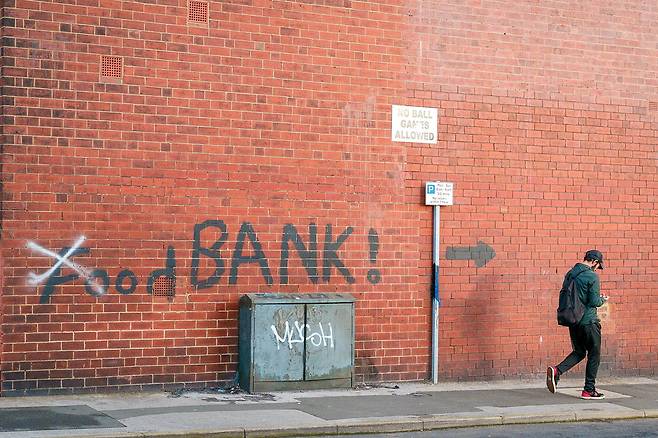 영국 리즈 지역에서 한 남성이 '푸드뱅크' 라고 쓰인 벽 앞을 걸어가고 있다. 브렉시트 이후 양극화가 심화되면서 북부 지역의 빈곤이 심각한 사회문제로 떠올랐다. 블룸버그