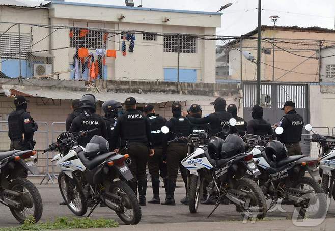 22일(현지시간) 에콰도르 남서부 마찰라의 한 교도소에서 폭동이 발생한 가운데 경찰관들이 해당 교도소 밖에서 대기하고 있다. 경쟁 관계에 있던 갱단이 충돌하면서 발생한 폭동으로 인해 수감자 13명과 교도관 1명이 사망했다. 2025.09.22 ⓒ AFP=뉴스1 ⓒ News1 김지완 기자