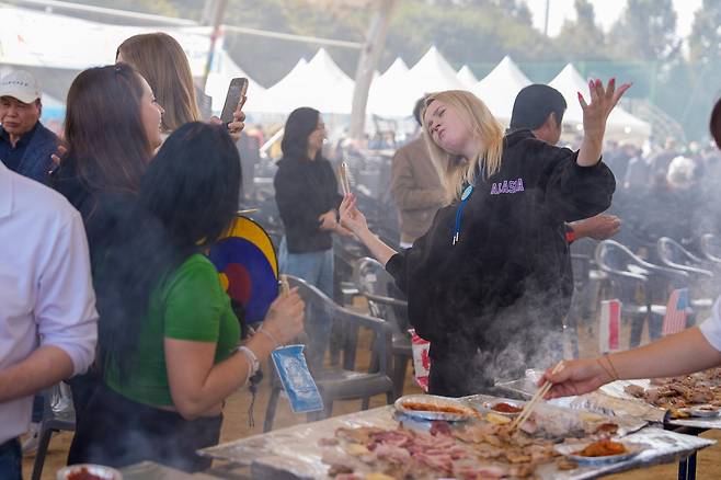 27일 오전 10시 30분 증평인삼골 축제장에 오면 홍삼포크 삼겹살을 무료로 맛볼 수 있다. 사진은 지난해 축제 때 삼겹살을 즐기며 사진을 찍는 외국 관광객의 모습. 증평군 제공