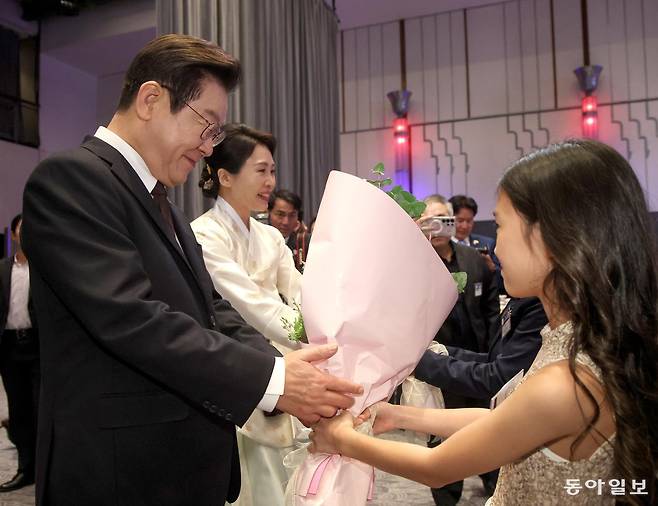 이재명 대통령과 김혜경 여사가 22일 오후 뉴욕의 한 호텔에서 열린 동포 만찬 간담회에서 화동의 꽃다발을 받고 있다. 뉴욕=송은석 기자 silverstone@donga.com