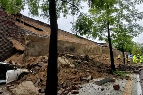 Firefighters carry out rescue operations after a retaining wall under an overpass collapsed and crushed a vehicle at the Gajang Interchange in Osan, Gyeonggi, around 7:04 p.m. on July 16. [GYEONGGI FIRE AND DISASTER HEADQUARTERS]