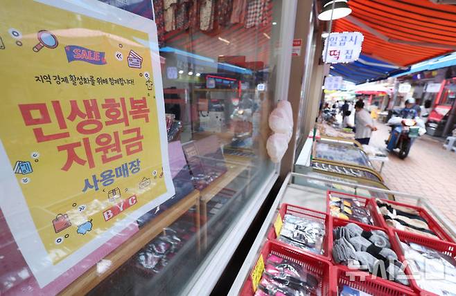 [서울=뉴시스] 김진아 기자 = 소득 상위 10%를 제외한 국민 90%에게 1인당 10만원을 추가 지급하는 2차 '민생회복 소비쿠폰' 신청과 지급이 시작된 지난 22일 서울의 한 전통시장에 민생 회복 지원금 사용가능 안내문이 붙어 있다. 2025.09.22. bluesoda@newsis.com