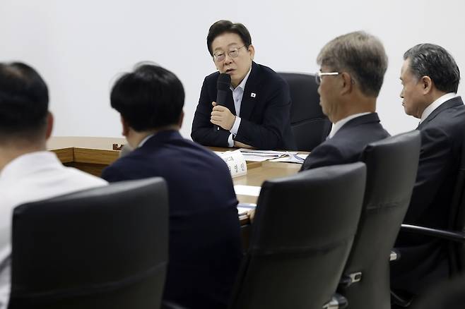 이재명 대통령이 지난 7월 25일 SPC 삼립 시흥 공장에서 열린 산업재해 근절 현장 노사간담회에서 임원진에게 사고 경위와 근로 환경을 묻고 있다. [사진 | 뉴시스]