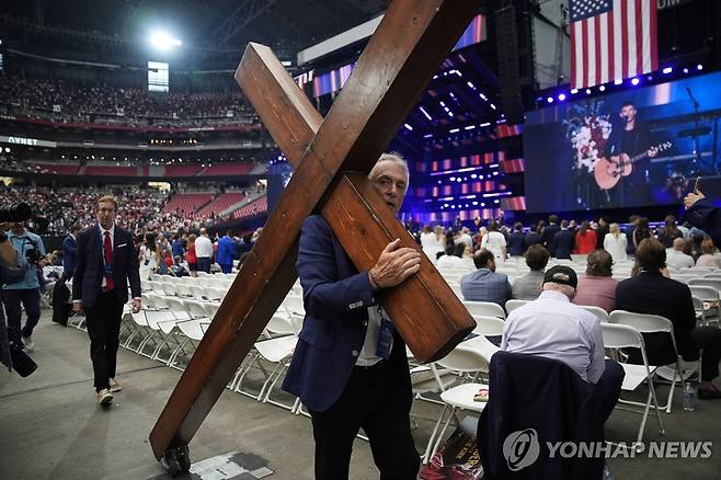 찰리 커크 추모식에 십자가 메고 온 참석자 [AP 연합뉴스 자료사진]
