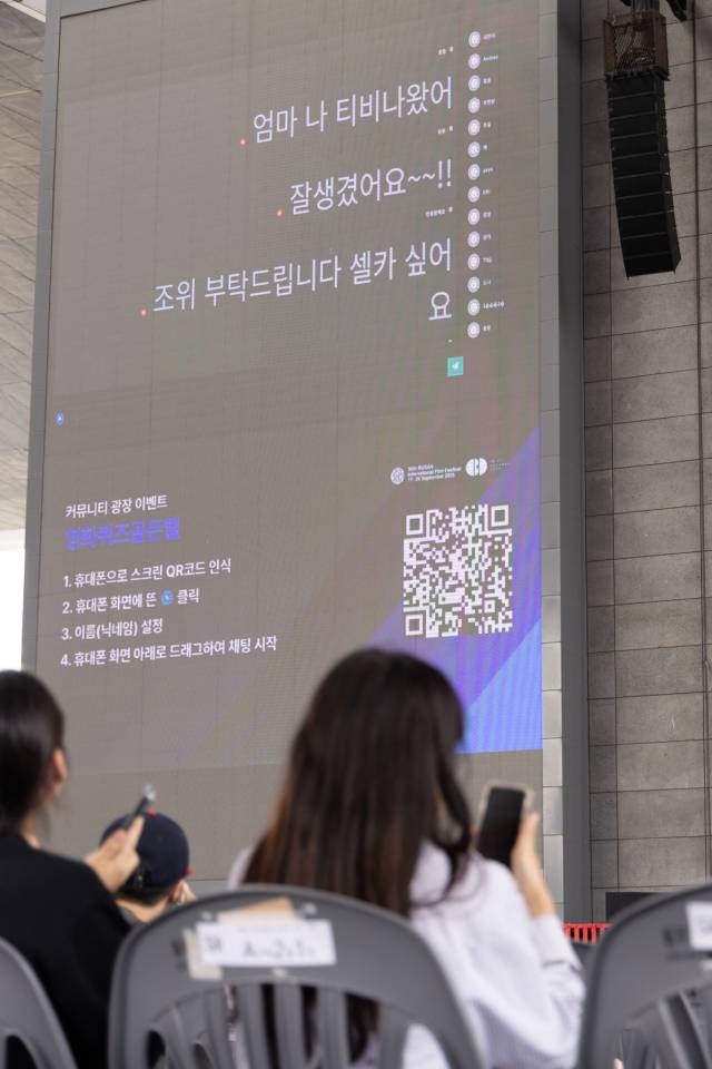 24일 오후 부산 해운대구 영화의전당 야외무대에서 열린 영화퀴즈골든벨 참석자들이 휴대폰으로 답을 입력하고 있다. 정성운 인턴기자