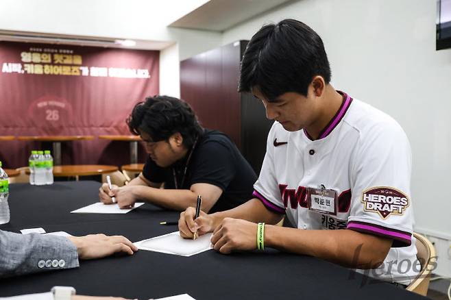 신인드래프트 전체 1순위로 키움히어로즈에 지명된 천안북일고 투수 박준현이 계약서에 사인을 하고 있다. 사진=키움히어로즈