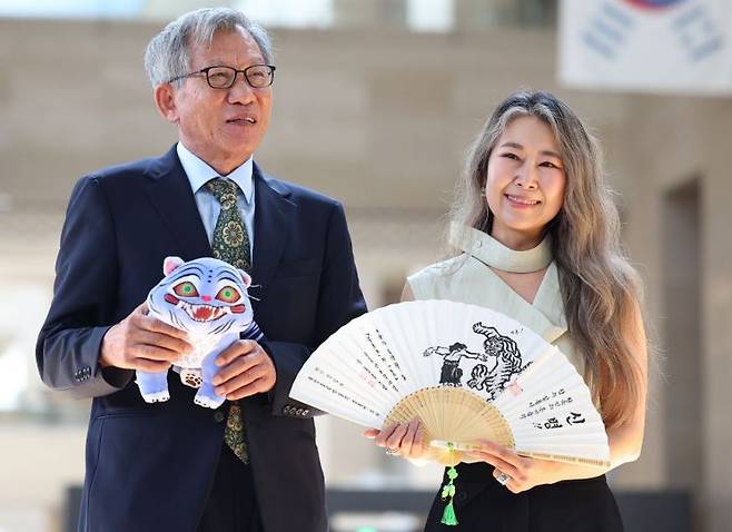 유홍준 국립중앙박물관장(왼쪽)과 넷플릭스 애니메이션 '케이팝 데몬 헌터스'의 매기 강 감독이 지난달 21일 서울 용산구 국립중앙박물관에서 선물을 주고 받은 뒤 기념촬영을 하고 있다.   [사진 제공= 연합뉴스]