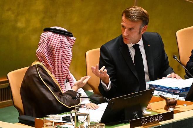 프랑스 에마뉘엘 마크롱 대통령(오른쪽)이 22일 뉴욕 유엔본부에서 열린 팔레스타인 문제 평화적 해결과 두 국가 해법 이행을 위한 고위급 회의에서 파이살 빈 파르한 사우디 외교장관과 대화하고 있다. /EPA 연합뉴스