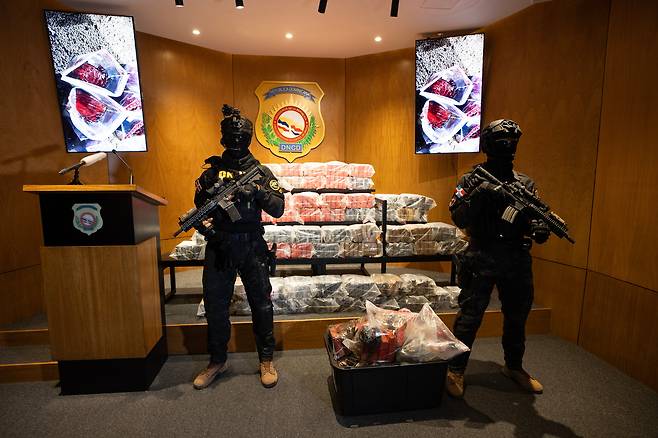 21일 도미니카 공화국 마약통제국(DNCD) 회원들이 최근 카리브해에서 미군의 폭격을 받은 마약운반선에서 회수한 코카인을 지키고 있다. 도미니카 공화국은 공격을 받은 선박 잔해에서 377개의 마약 소포를 확보했다고 밝혔다. /EPA 연합뉴스