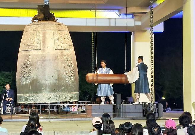 24일 저녁 국립경주박물관 앞 뜨락 종각에서 펼쳐진 성덕대왕 신종 타음 조사 공개 행사 모습. 전 보신각 종지기 신철민씨와 주철장 이수자 원천수씨가 종 치는 막대인 당목을 부여잡고 종을 치고 있다. 노형석 기자