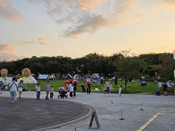 지난 19일 첫 운영을 시작한 야외도서관 '틈'. 강정보 디아크 야외광장에서 책, 예술, 자연이 어우러진 풍경 속 여유를 즐기는 시민들의 모습이 눈에 띈다 [사진=달성군]