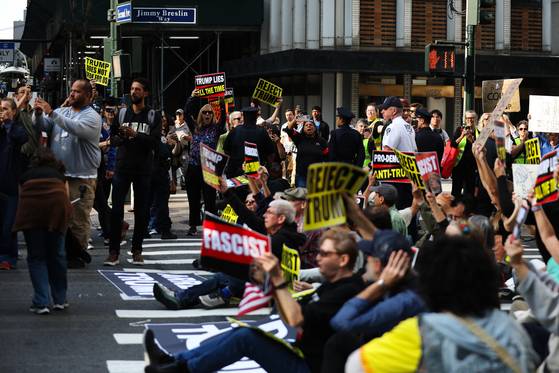 제80차 유엔 총회가 열린 23일(현지시간) 미국 뉴욕에서 시위대가 42번가 교차로에서 시위를 벌이는 모습을 사람들이 지켜보고 있다. AP=연합뉴스