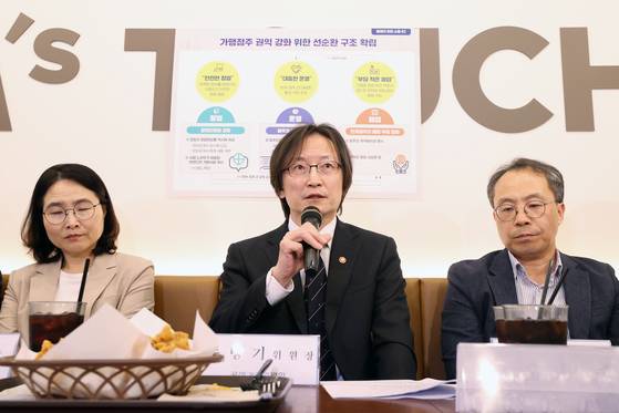 주병기 공정거래위원장(가운데)이 23일 서울 마포구 맘스터치 마포대흥역점에서 가맹업계 관계자와 점주들을 만나 “가맹산업은 종사자 수 100만 명을 넘어섰지만, 불공정한 거래 관행이 여전하고 점주의 생계도 위협받고 있다”며 권익 강화 종합 대책에 관해 설명하고 있다. [연합뉴스]