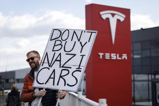 Demonstrators gather outside a Tesla dealership to protest and boycott Tesla amid Elon Musk's controversial political positions in the Donald Trump administration in London on March 15. [EPA/YONHAP]