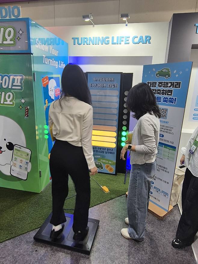 24일 서울 강남구 코엑스에서 열린 2025 대한민국 ESG 친환경대전에서 탄소중립포인트 부스를 찾은 방문객이 스테퍼를 밟으며 자동차 탄소중립포인트에 대해 배우고 있다. 차승윤 기자&nbsp;