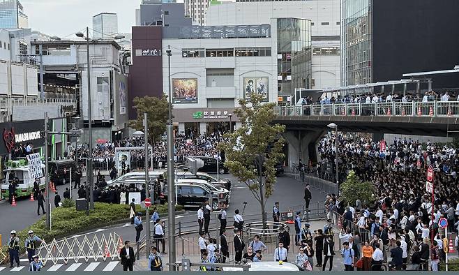 24일 일본 도쿄 아키하바라역 근처에서 시민들이 삼엄한 경비 속에 열린 자민당 총재선거 합동연설회를 지켜보고 있다. 도쿄=유태영 특파원
