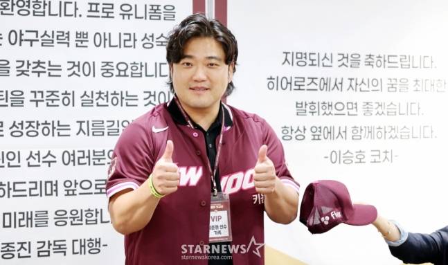 키움 1순위 지명된 박준현이 24일 고척스카이돔에서 열린 키움 2026 새내기들 환영행사에서 아버지 박석민에게 유니폼을 입혀주고 있다. 모자를 쓰라는 아내의 요청을 거부하고 있는 박석민. /사진=강영조 선임기자