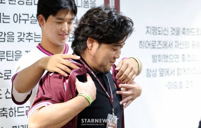 키움 1순위 지명된 박준현(왼쪽)이 24일 고척스카이돔에서 열린 키움 2026 새내기들 환영행사에서 아버지 박석민에게 유니폼을 입혀주고 있다. /사진=강영조 선임기자