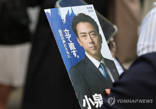 "자민당을 다시 세우겠습니다" (도쿄=연합뉴스) 박상현 특파원 = 24일 오후 일본 도쿄 아키하바라역 근처에서 열린 집권 자민당 총재 선거 연설회에서 참가자가 고이즈미 신지로 농림수산상 홍보 팸플릿을 들고 있다. 팸플릿에 '다시 세우다'를 뜻하는 글자가 보인다.