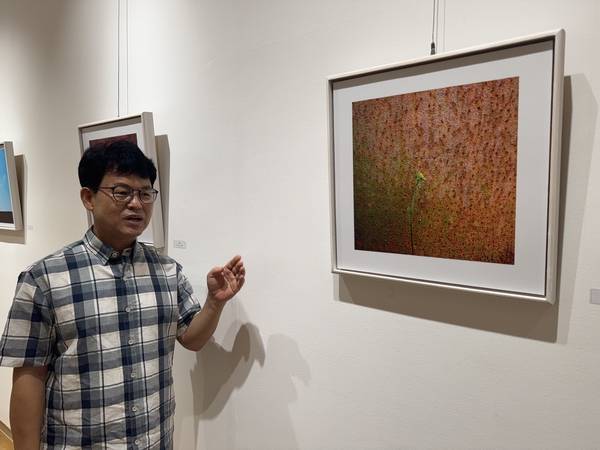 이상원 사진가가 경남은행 본점 갤러리에서 열리는 다섯 번째 개인전에 선보인 작품을 설명하고 있다. /이서후 기자