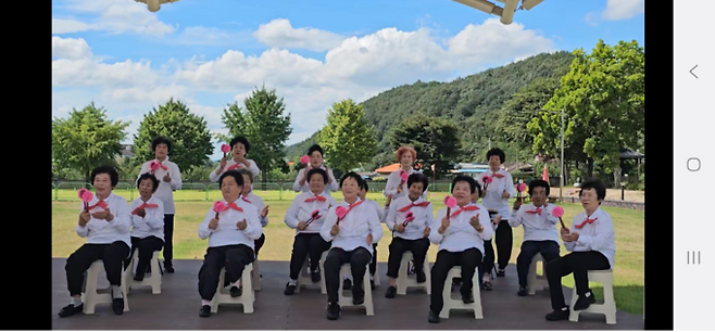 ▲ 의성군 사곡면 청춘센터 야외무대에서 '거북이 날다' 회원들이 흰색 단체복을 입고 분홍색 소품을 활용한 합동 공연을 펼치며 지역민과 소통하고 있다. 사곡면 오상2리 제공