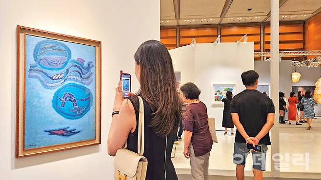 ‘프리즈 서울 2025’의 학고재갤러리 부스에 걸린 김환기의 ‘구름과 달’(1962) 앞에 한 관람객이 오래 머물렀다. 작품은 20억원에 팔렸다. 올해 ‘키아프·프리즈 서울’에서 팔린 한국 작가의 작품 중 최고가다(사진=오현주 문화전문기자).