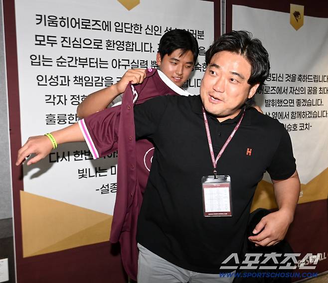 24일 고척스카이돔에서 열린 KIA와 키움의 경기, 경기 전 진행된 키움 히어로즈의 2026 신인선수 환영행사에서 1라운드 전체 1순위로 키움에 입단한 박준현이 아버지 박석민 전 코치에게 자신의 첫 친필 사인이 담긴 유니폼을 선물하며 유니폼을 입혀주고 있다. 고척=허상욱 기자wook@sportschosun.com/2025.09.24/
